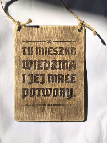 Tablica tabliczka z napisem napis Tu mieszka Wiedźma i jej futrzaste potwory.