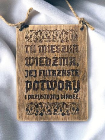 Tablica tabliczka z napisem napis Tu mieszka Wiedźma, jej futrzaste potwory i przystojny diabeł